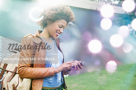Glowing lights and young woman using smartphone Glowing lights and young woman using smartphone