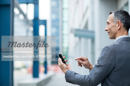 Businessman using touchscreen on smartphone
