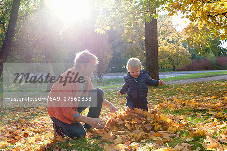 Father and son playing with autumn leaves