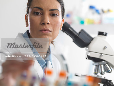 Female scientist about to view a blood sample under a microscope