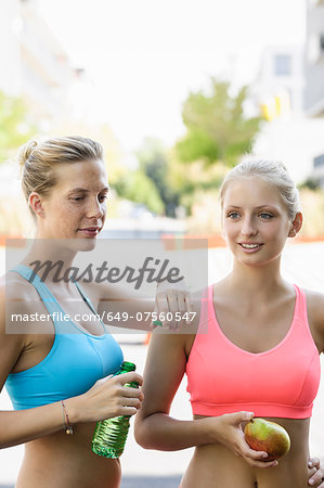 Two young female runners taking a break