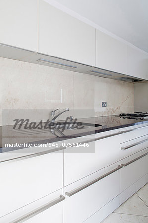 Detail of modern kitchen with white fitted units, London