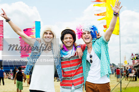 Portrait of cheering friends in wigs at music festival
