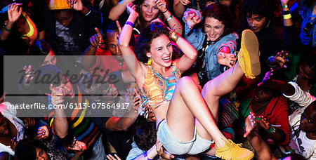 Enthusiastic woman crowd surfing at music festival Enthusiastic woman crowd surfing at music festival