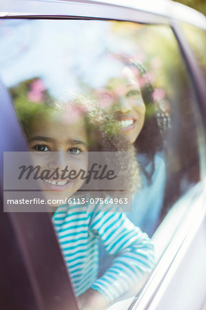 Portrait of smiling car looking out car window