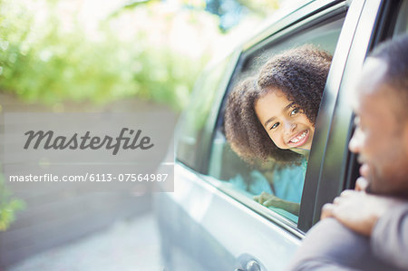 Father and daughter leaning out car windows