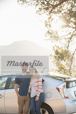 Portrait of happy couple outside car