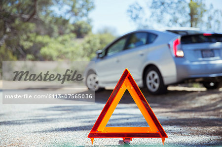 Car at roadside behind warning triangle