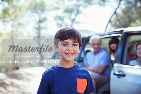 Portrait of smiling boy outside car