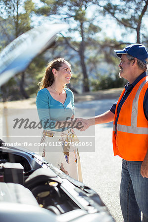 Woman shaking hands with roadside mechanic