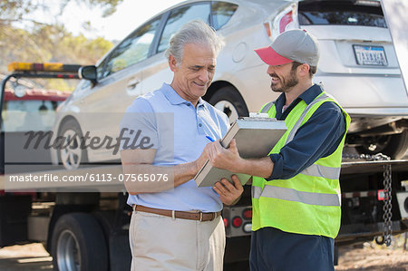 Roadside mechanic and man with paperwork