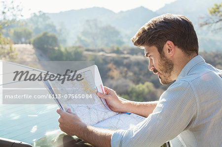 Man looking at map outside car