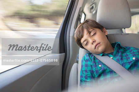 Boy sleeping in back seat of car