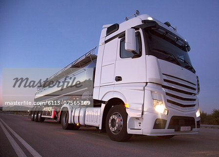 Stainless steel milk tanker on the road at night