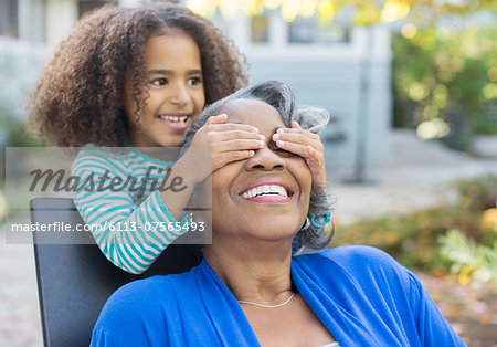 Granddaughter surprising grandmother on patio