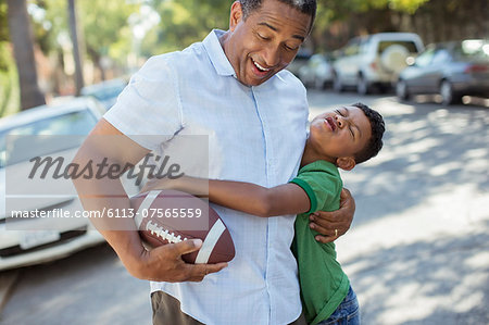 Grandson tackling grandfather with football