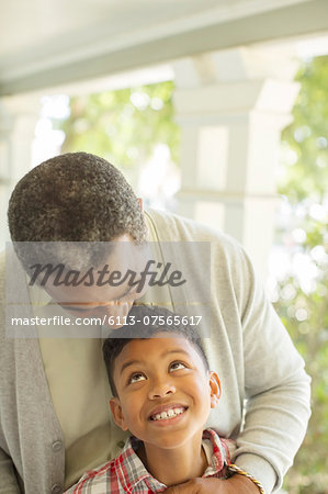 Grandfather hugging grandson on porch