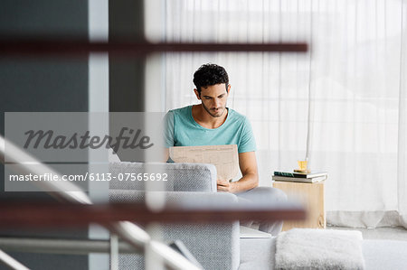 Man reading newspaper in livingroom