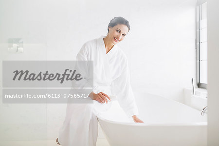 Portrait of smiling woman in bathrobe preparing bath