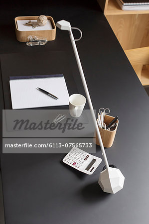 Objects and modern lamp on home office desk