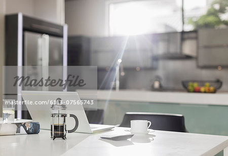 Morning sun shining on laptop in kitchen