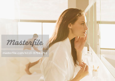 Woman looking at face in mirror Woman looking at face in mirror