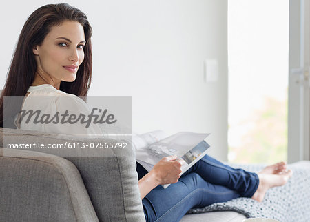 Portrait of confident woman reading magazine on chaise lounge Portrait of confident woman reading magazine on chaise lounge
