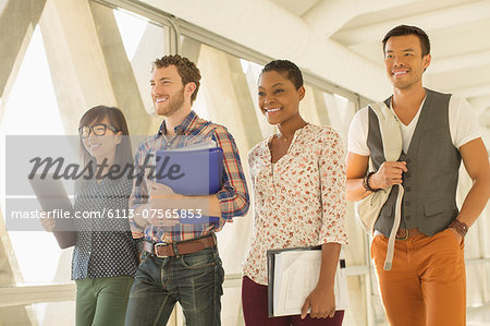 Confident casual business people walking in office corridor