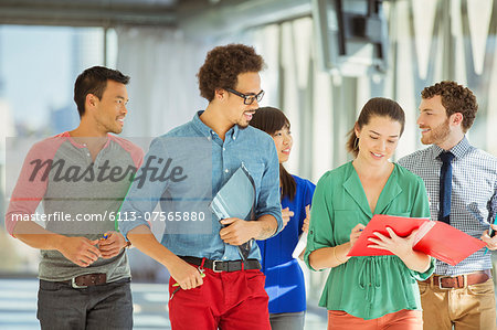 Creative business people walking in office corridor Creative business people walking in office corridor