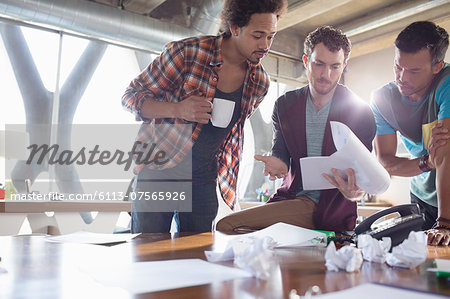 Creative businessmen reviewing paperwork in meeting