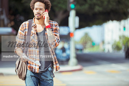 Man talking on cell phone in urban crosswalk