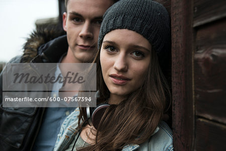 Close-up portrait of teenage girl and young man outdoors, looking at camera, Germany