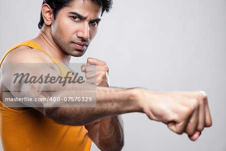 Handsome Indian man giving a knockout punch