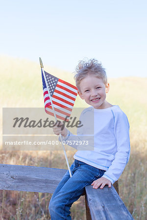 cute little boy holding american flag and celebrating independence day