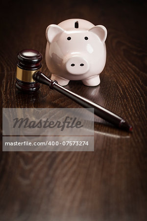 Gavel and Piggy Bank on Wooden Table.