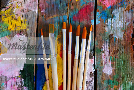 Photo of paint brushes on wooden background
