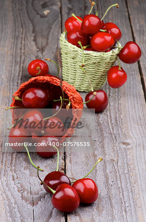 Ripe Sweet Cherries in Two Wicker Baskets closeup on Rustic Wooden background