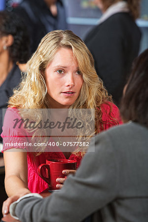 Caring young woman with friend in coffee house