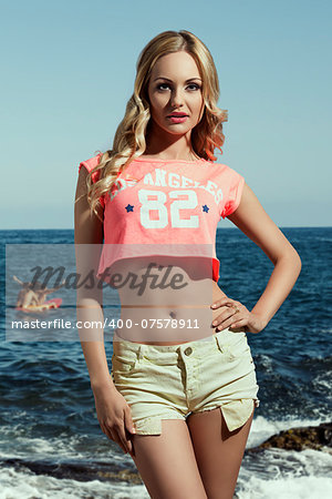 beauty casual woman with long wavy blonde hair and summer clothes wearing american top and sexy shorts