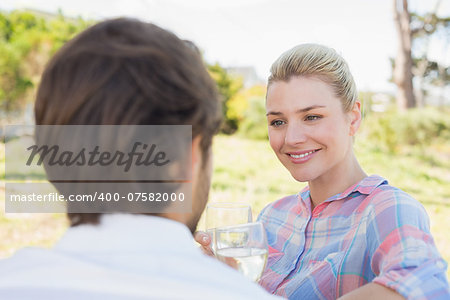 Cute couple sitting in the garden enjoying wine together on a sunny day