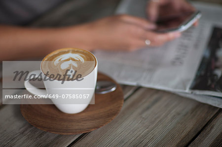 Close up of young woman using cellphone in cafe