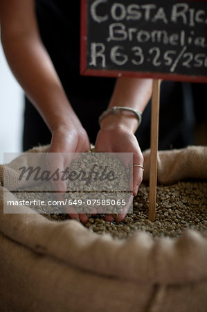 Close up of young female waitress holding coffee beans