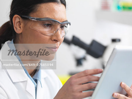 Scientist viewing test results on a digital tablet in lab