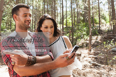 Young couple in forest, man pointing