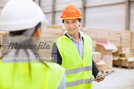 Supervisor shaking hands with trainee in distribution warehouse