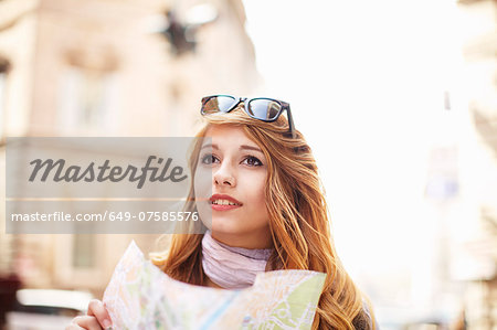 Young woman with street map looking lost, Rome, Italy