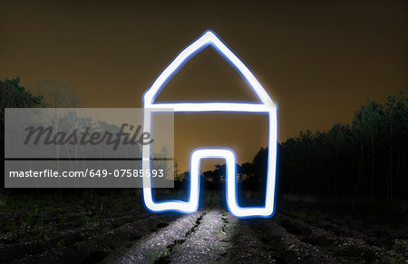 Field landscape at night with light painted drawing of house