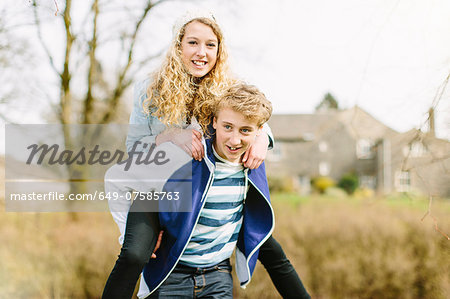 Teenage boy giving girlfriend piggyback