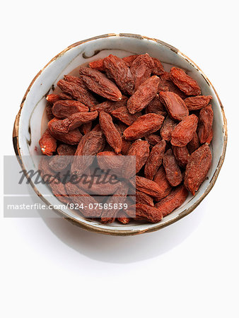 A bowl of goji berries on a white background