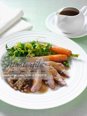 Roast turkey thigh with stuffing carrots cabbage peas and gravy